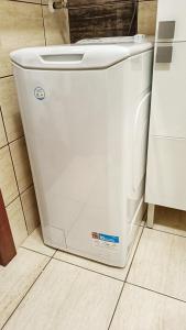 a white washing machine sitting on the floor in a kitchen at Apartament Jola in Polanica-Zdrój