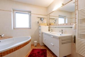a bathroom with a tub and a sink and a mirror at Apartment Steindl in Längenfeld +18 photos