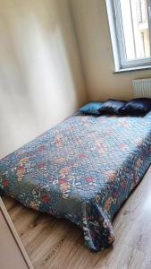 a bed in a bedroom with a blanket on the floor at Apartament Jola in Polanica-Zdrój
