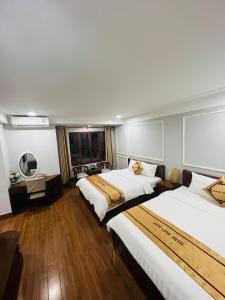 Una habitación de hotel con dos camas y un espejo. en Sapa Land Hotel, en Sa Pa 46 fotos más
