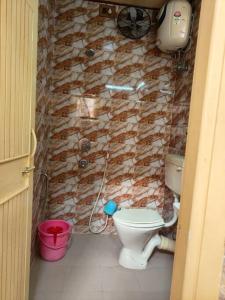 uma casa de banho com um WC e uma parede de pedra em Premium Apartment, Kolkata Airport em kolkata