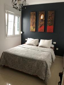 ein Schlafzimmer mit einem großen Bett mit vier Gemälden an der Wand in der Unterkunft Casa Mochi in La Laguna