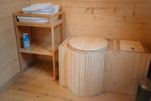 a wooden sauna with a toilet and towels at Berta Tiny house in Verlaine