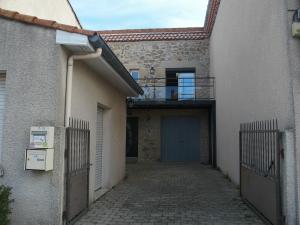 un callejón con un edificio con una puerta y un garaje en Gît' de Pom', en Saint-Romain-de-Lerps