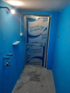 Zimmer mit blauen Wänden und einer Tür mit Treppen in der Unterkunft Vrindavan Home Stay,Varanasi. in Varanasi