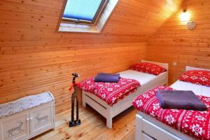 - une chambre avec 2 lits dans une cabane en rondins dans l'établissement Domki całoroczne NEMO, à Ustronie Morskie