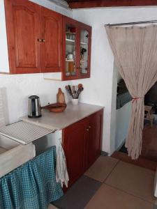 a kitchen with wooden cabinets and a counter top at Houni House in Agriovótanon