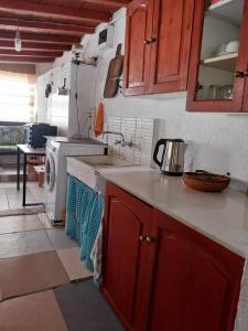 a kitchen with a sink and a washing machine at Houni House in Agriovótanon
