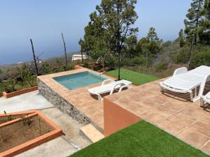 蓬塔戈爾達的住宿－helios casa vacacional，一个带两把草坪椅和泳池景的游泳池