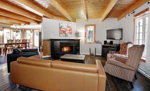 - un salon avec un canapé et une cheminée dans l'établissement Chalets Alpins - 11 Chemin des Skieurs, à Stoneham