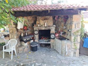 an outdoor kitchen with a stove and a chair at Escapada Perfecta en Las Jaras in Pelayos de la Presa