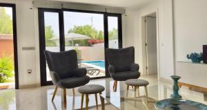 two chairs and a table in a room with a pool at Apartamento Tenerife Vista Bella in Santa Cruz de Tenerife