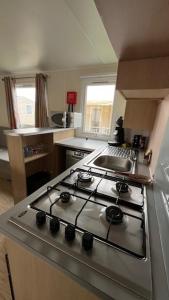 a kitchen with a stove top oven in a kitchen at Mobilhome cosy tout confort 6-8 personnes in Valras-Plage