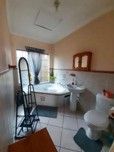 a bathroom with a tub and a toilet and a sink at Comfort at its Best! in Brits