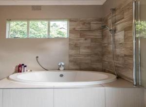 uma casa de banho com uma banheira grande e um chuveiro em Urban Suite Fourways em Sandton