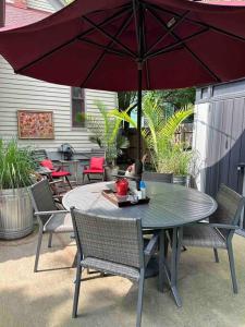 a table and chairs with a red umbrella on a patio at Corktown Cottage in Detroit