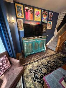 a living room with a fireplace and a staircase with pictures at Corktown Cottage in Detroit