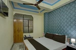 a bedroom with a bed and a blue wall at OYO Flagship HOTEL RAJENDRA PALACE in Kānpur