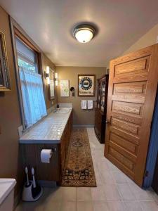 a bathroom with a large shower and a wooden door at Corktown Cottage in Detroit