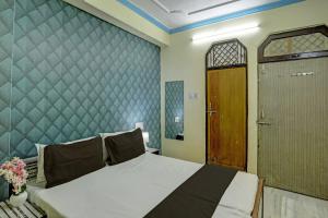um quarto com uma cama grande e uma porta de madeira em OYO Flagship HOTEL RAJENDRA PALACE em Kanpur