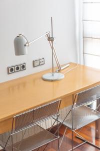 un escritorio con 2 sillas y una lámpara. en Mazi Apartments Colón, en Vic