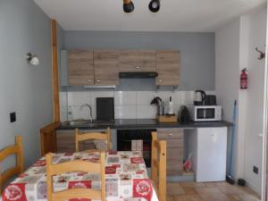 a kitchen with a table and chairs and a kitchen with a table and a table at Studio à Murbach au calme in Murbach