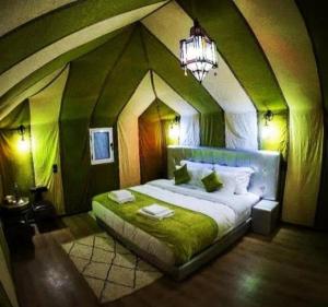 una camera da letto con un grande letto in una stanza grande di Merzouga luxurious Camp a Merzouga