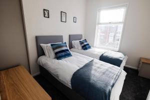 a bedroom with two beds with blue pillows at The Nest at Blackburn in Cherry Tree
