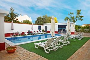 ein Swimmingpool mit Liegestühlen und Sonnenschirmen in der Unterkunft Solar de Alqueva in Reguengos de Monsaraz