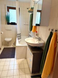 ein Badezimmer mit einem Waschbecken, einer Badewanne und einem WC in der Unterkunft La Pura Vida in Bühlertann