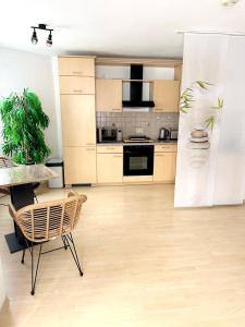 uma cozinha com uma mesa e uma cadeira num quarto em La Pura Vida em Bühlertann