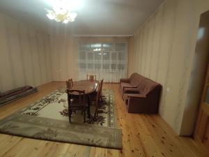 - un salon avec une table, des chaises et un canapé dans l'établissement Sheki city villa, à Shaki