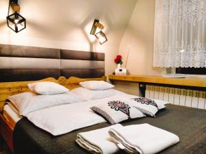 um quarto com 2 camas e toalhas brancas em Pokoje Gościnne " W zasięgu Tatr" em Kościelisko