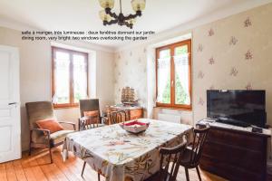 La Maison de Vacances de Colmar et son jardin في كولمار: غرفة معيشة مع طاولة وتلفزيون