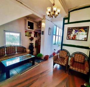 a living room with a table and two chairs at Hotel Tribhuvan Ranikhet Near Mall Road - Mountain View -Parking Facilities - Excellent Customer Service Awarded - Best Seller in Rānīkhet