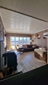 un soggiorno con divano e TV di Cosy cabin in North-Norway, Nearby Senja. a Sorreisa