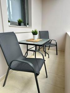 trzy krzesła i stół w pokoju w obiekcie Eleni's apartment near airport w Heraklionie