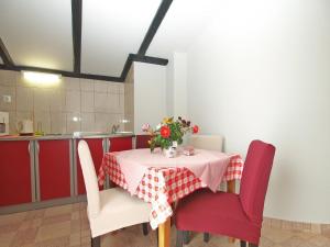 una mesa con sillas rojas y un jarrón de flores. en Ferienwohnung für 4 Personen ca 45 qm in Fažana, Istrien Istrische Riviera - b54596, en Fažana