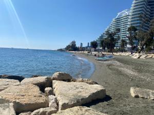 een strand met rotsen op het zand en gebouwen bij Andreas Apartment in Limassol