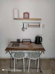 a table with two stools in a kitchen with a clock at Διαμέρισμα Έλλη in Rethymno +17 photos