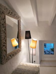 a bedroom with a mirror and a lamp and a bed at La Casita de Sandra in Alora