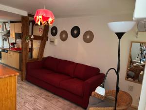 un soggiorno con divano rosso e una cucina di La Légende des 2 Pierres a Eguisheim