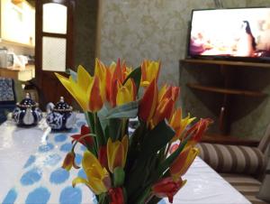 un vaso pieno di fiori colorati su un tavolo di willa hostel a Yunusobod