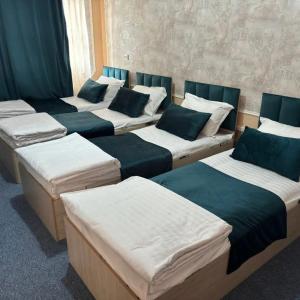 a group of four beds in a room at willa hostel in Yunusobod