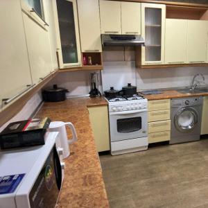 a kitchen with a stove and a stove top oven at willa hostel in Yunusobod