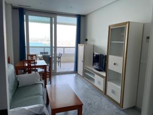 a living room with a couch and a tv and a table at Apartamentos Benivistas in Benidorm