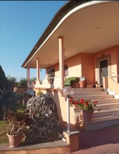 een huis met trappen en potplanten ervoor bij Villa Fiore in Nettuno
