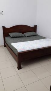 uma cama com uma estrutura de madeira num quarto em KJ HOMESTAY SUNGAI PETANI em Sungai Petani