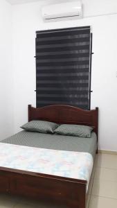 uma cama com uma cabeceira de madeira num quarto em KJ HOMESTAY SUNGAI PETANI em Sungai Petani