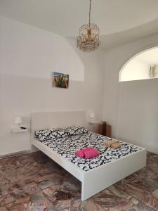 a white bedroom with a bed with a pink pillow at Borgo Di Taormina Apartments in Gaggi